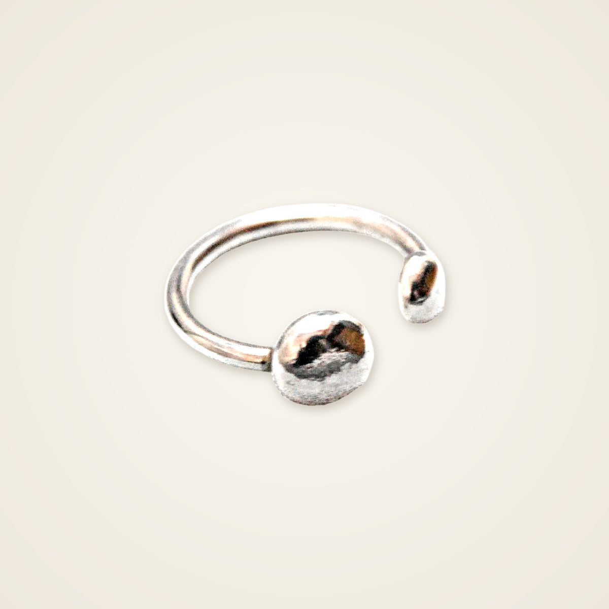 Anello Open Pepite in argento su sfondo crema